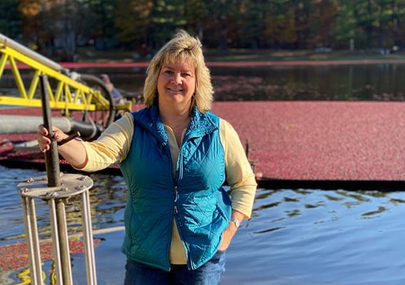 Dawn Allen stands in front of a bog with ripe cranberries ready for harvest