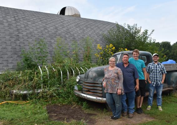 The Doudlah family standing in front of an antique truck