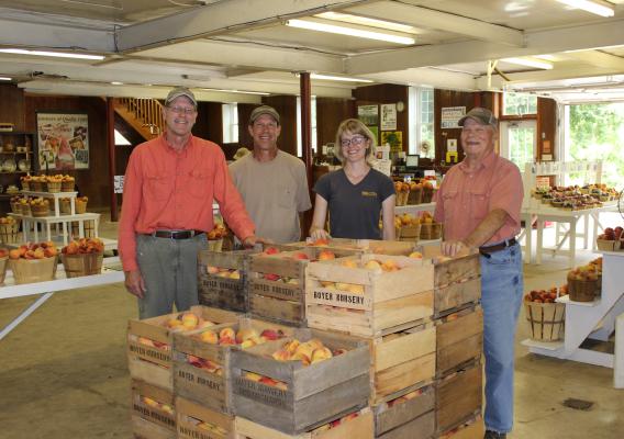 The Lowers family stands beside crates of fruit