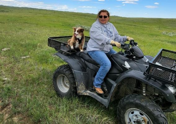A person and a dog on a four wheeler. 