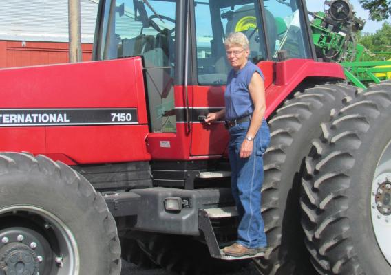 Person standing on tractor step