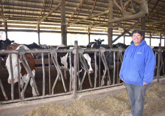 Paula Sue Steffen standing in front of cattle in feeding barn
