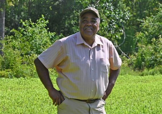 Person standing on grass while smiling