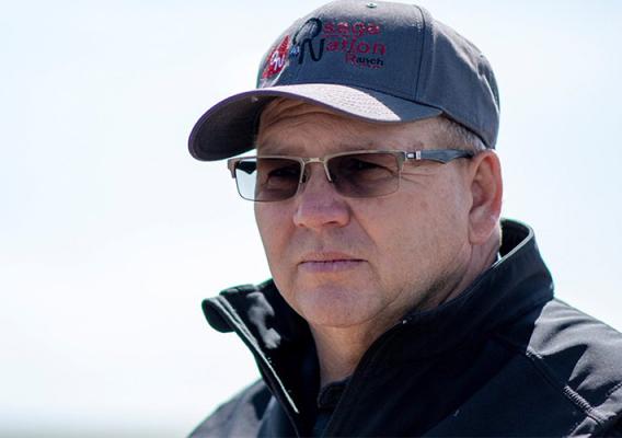 Person standing wearing a ball cap