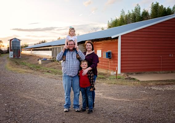 Four people standing in front of a barn