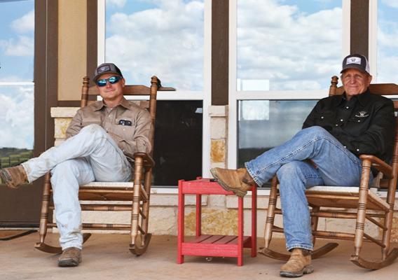 Two people sitting in rocking chairs on a porch
