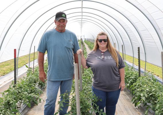 Two people standing in a high tunnel