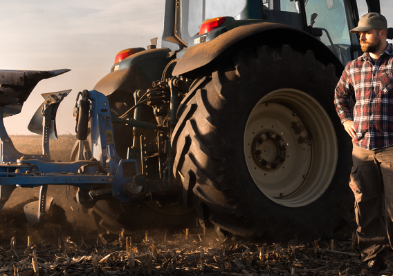 Man standing next to tractor wheel