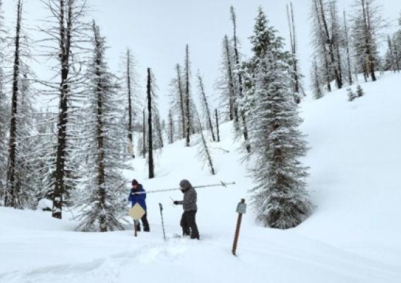 Two people standing in snow