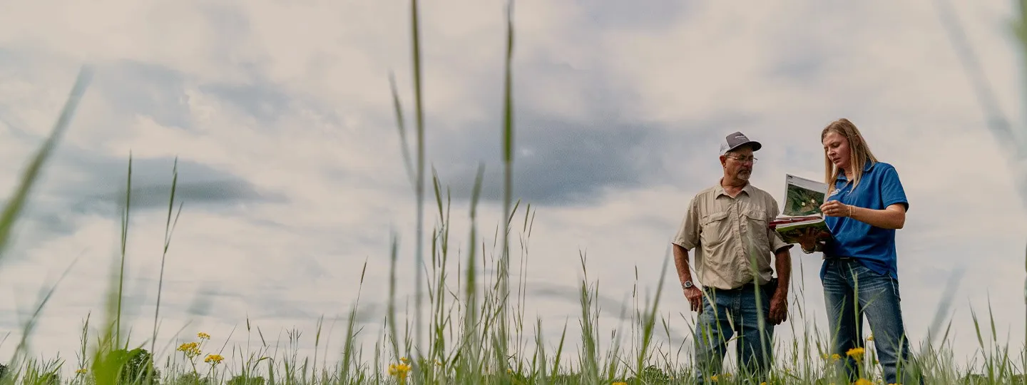 Two people standing in grass