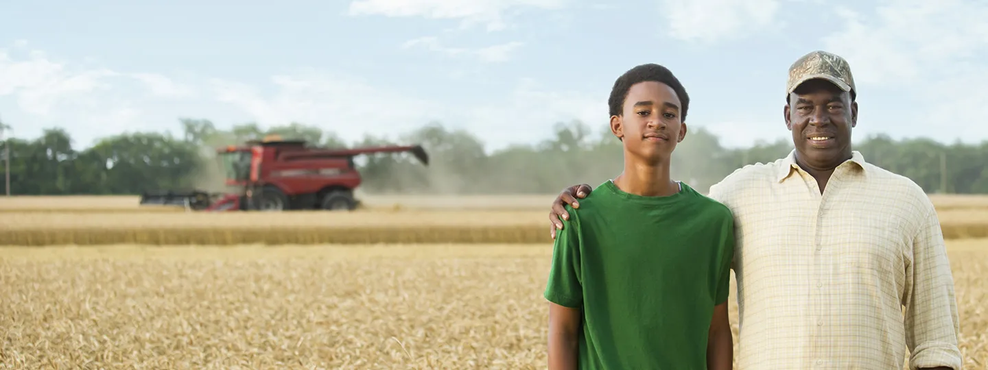 Two generations of Black farmers in wheat field