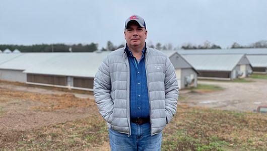 Person standing in front of poultry houses