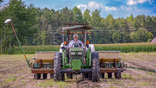 Person sitting in tractor while plowing