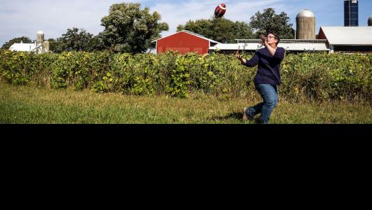 Person catching football in pasture
