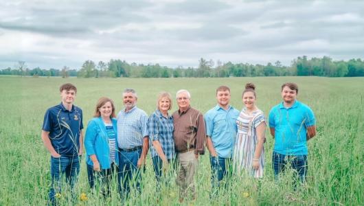 Eight people standing in a field