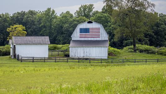 Two barns sitting in field