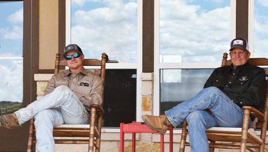Two people sitting in rocking chairs on a porch