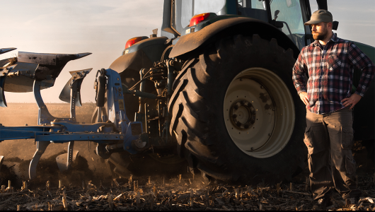 Man standing next to tractor wheel