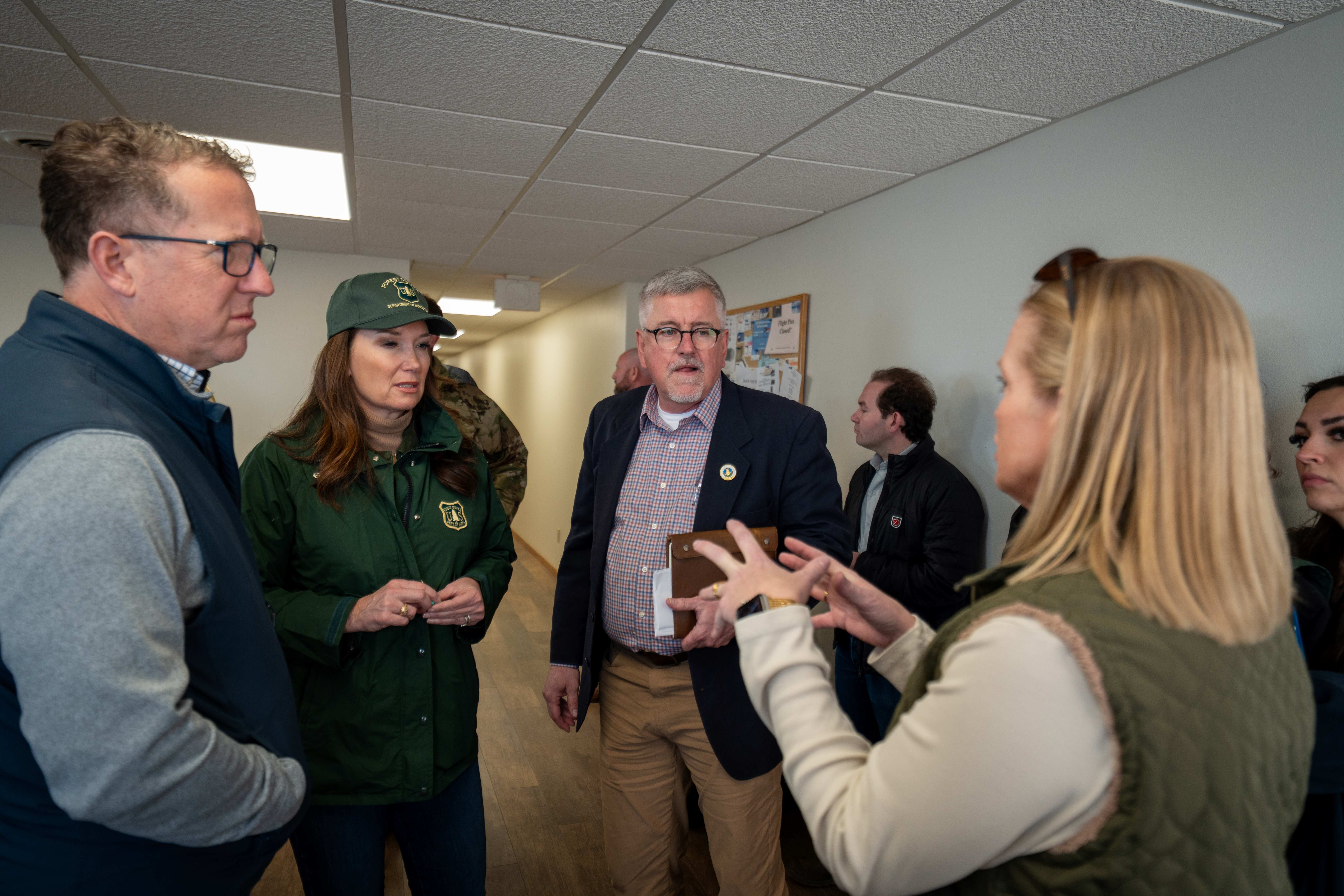 Four people standing in a hallway talking